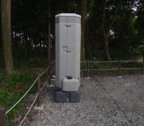 コンクリートの上に立っている仮設トイレの写真