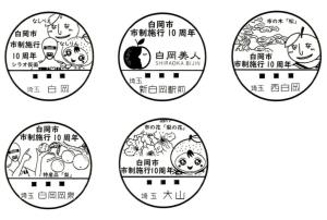 白岡市制施行10周年を記念した、各郵便局の5つの消印サンプル。梨のキャラクターなどのイラストが描かれている。