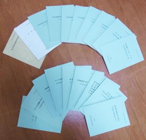 上下に扇形に並べて置かれている発掘調査報告書の写真