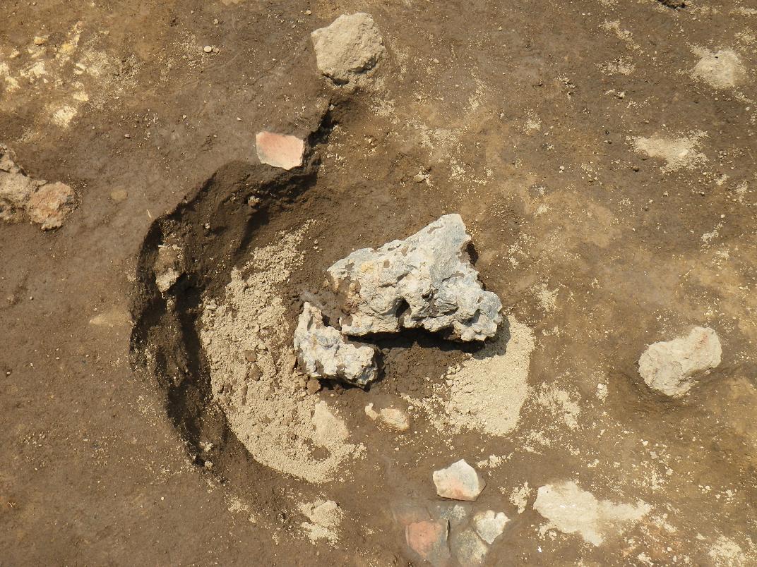 発掘後土の上に置かれた出土された鉄滓の写真