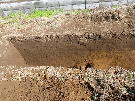 長方形に深く掘った発掘跡をアップで撮影した写真