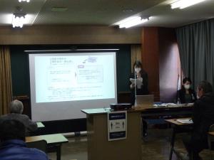 手元の資料を見ながら説明をしている女性の講師の方と、スクリーンや手元の資料を見ながら話を聞く受講者の方々の写真