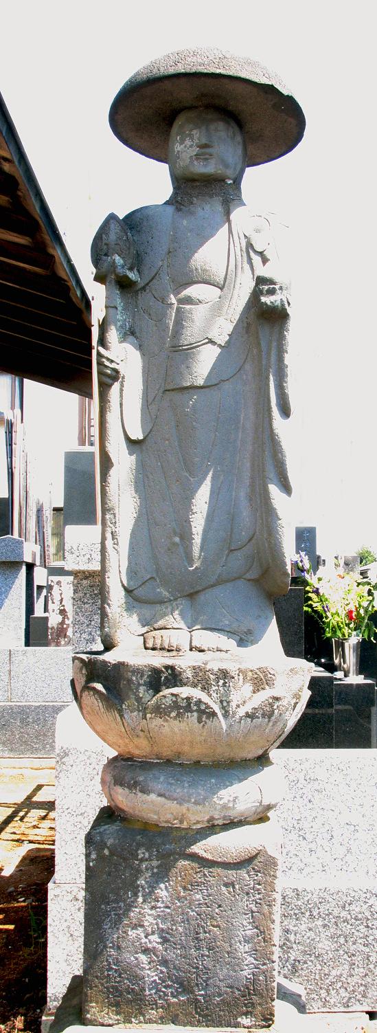 頭に笠を被り、右手に錫杖を持ち蓮の花の上に乗っている笠付地蔵の写真