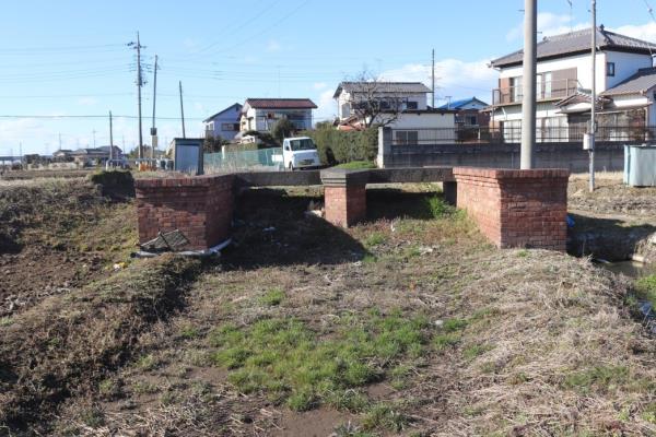 後方には住宅が密集し、前方には農業用水の取水のために設けられていた堰がある写真
