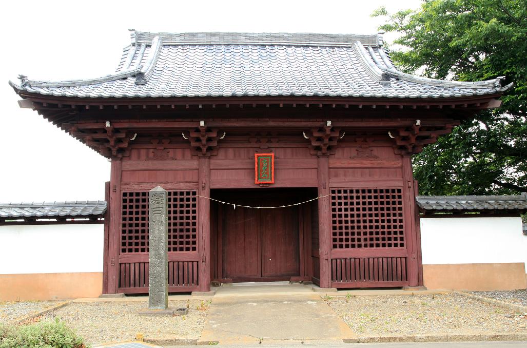 入母屋造りで朱塗りの八脚門がある忠恩寺山門の写真