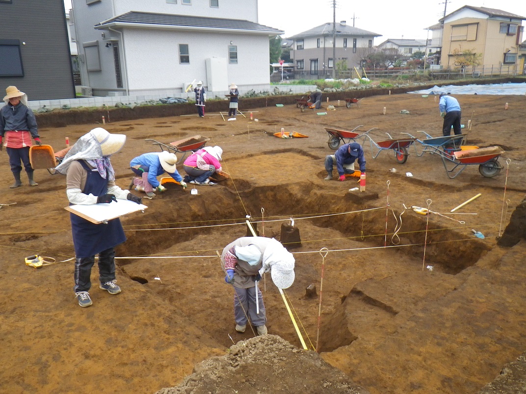 記録をする作業員や土を掘り発掘調査をする作業員の写真