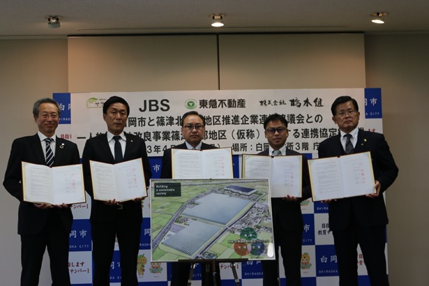パネルボートの前で藤井市長と白岡市一人施行土地改良事業篠津北東部地区協定を結んだ関係者の方々が協定書を手に持ち記念撮影している写真