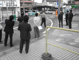 まち歩きをするスーツ姿の協議会委員の方々の後ろ姿の写真