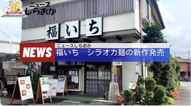 ニュースしらおかで福いちシラオカ麺の新作発売についての動画で外壁が白の2階建ての福いちの店舗入り口を写した写真
