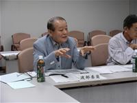 スーツを着た男性が手ぶりを交えながら話をしている様子の写真
