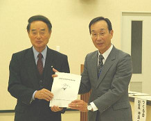 白岡市長と関係者の男性が資料を手に持ち並んで写っている開会セレモニーの記念写真