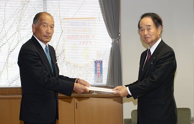 向かい合い、両手で一緒に答申書を持っている佐々木会長と市長の写真