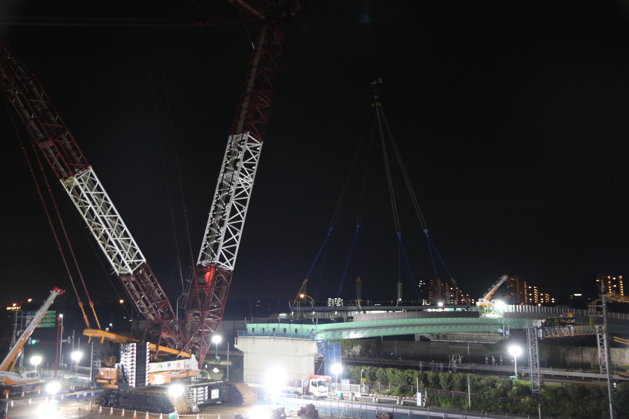 大型クレーンが橋を下ろしている写真