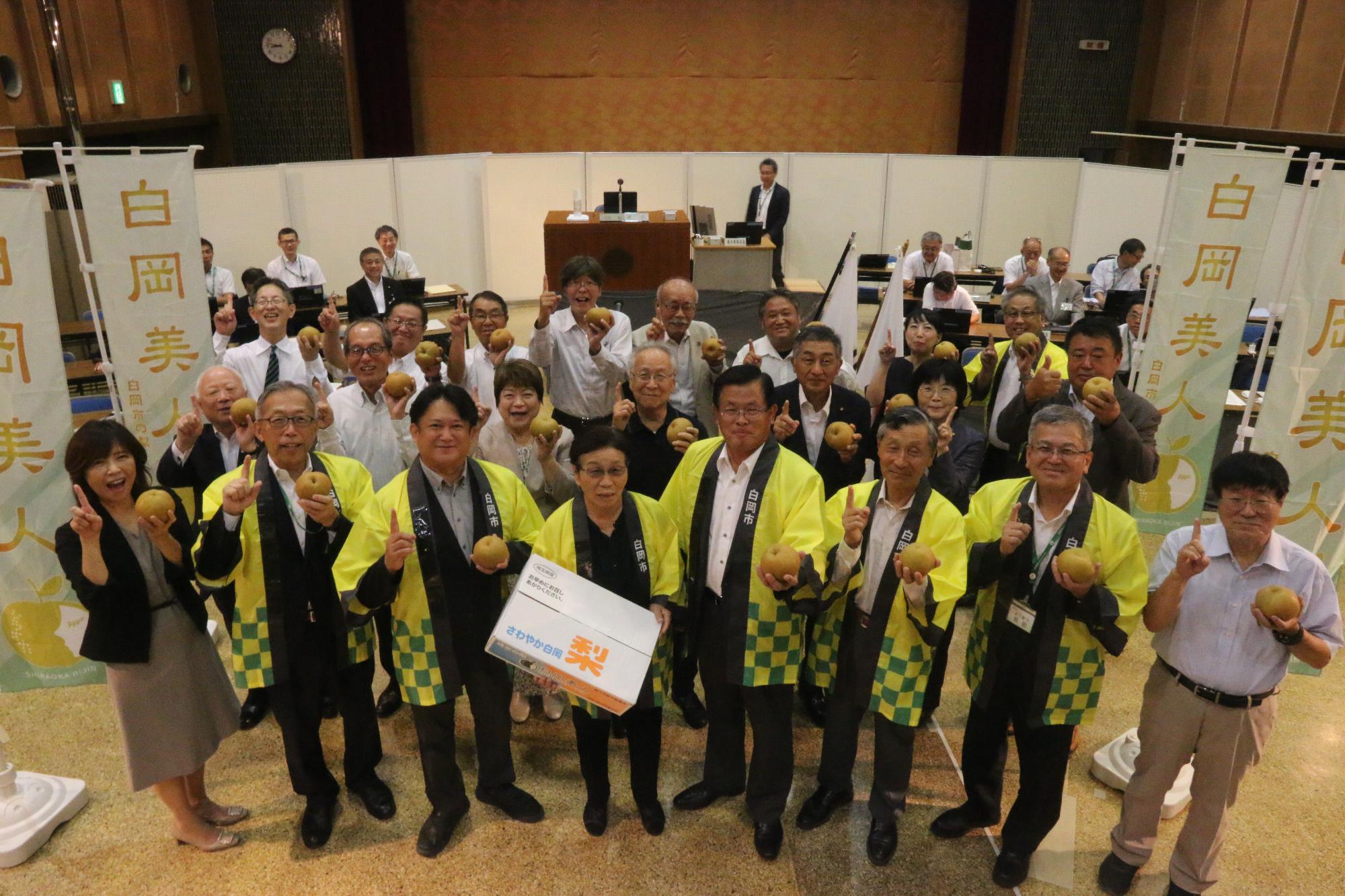 白岡市と白岡市議会が梨を持っている写真