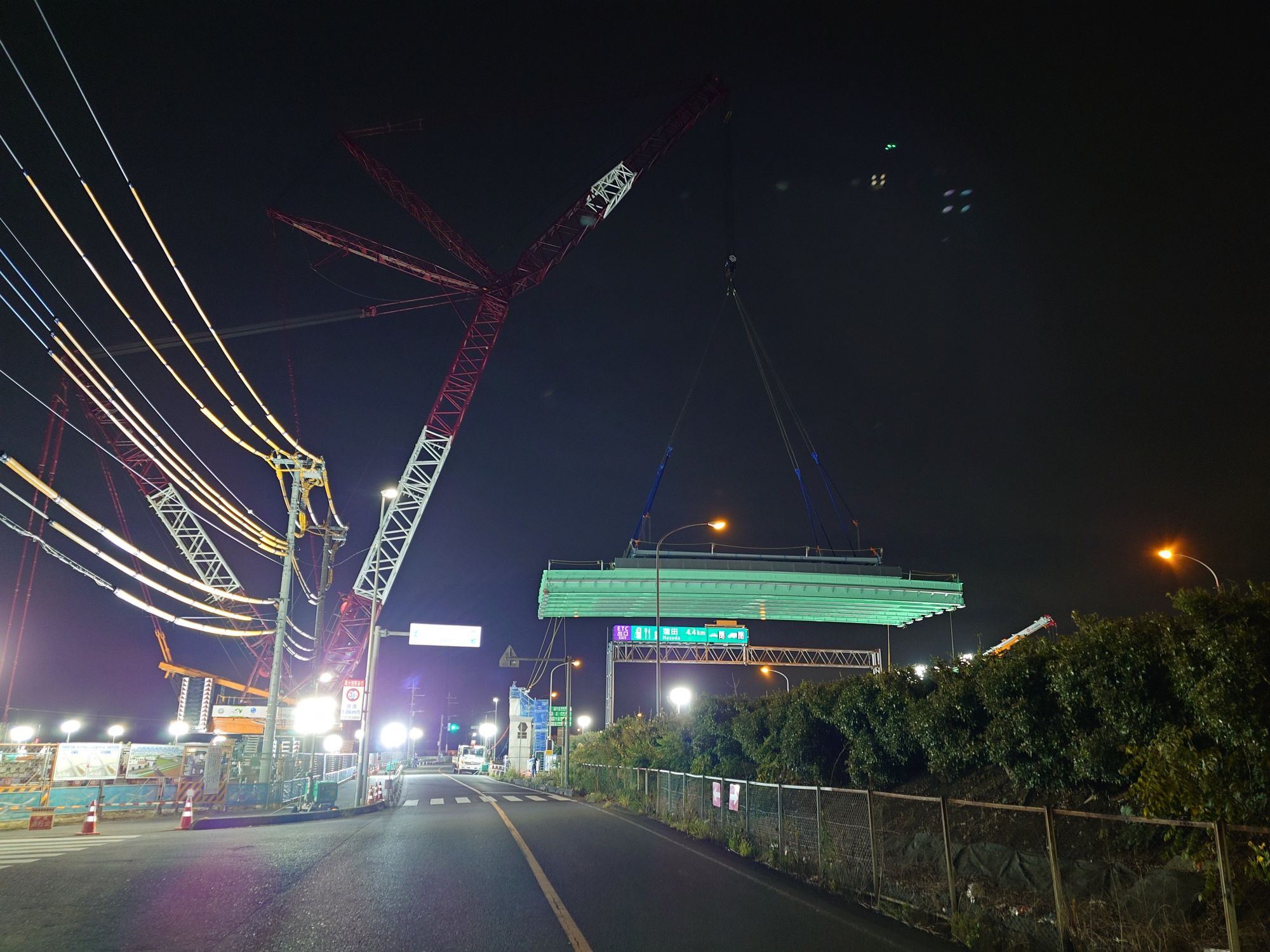 大型クレーンが橋桁を持ち上げる写真