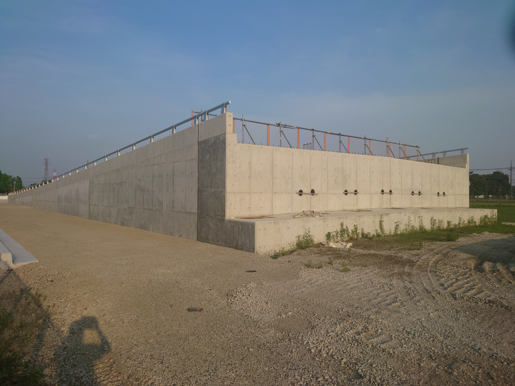 奥の方から手前へ緩やかな上り坂になっている整備中の都市計画道路の写真