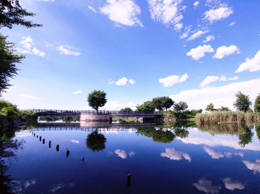 青空と白い雲が水面に映し出された7月フォトコンテスト受賞作品の写真