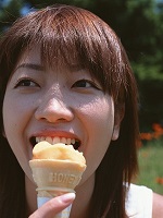 笑顔でアイスを食べる女性の写真