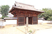 木製の屋根付きの門扉の忠恩寺の入口を写した写真