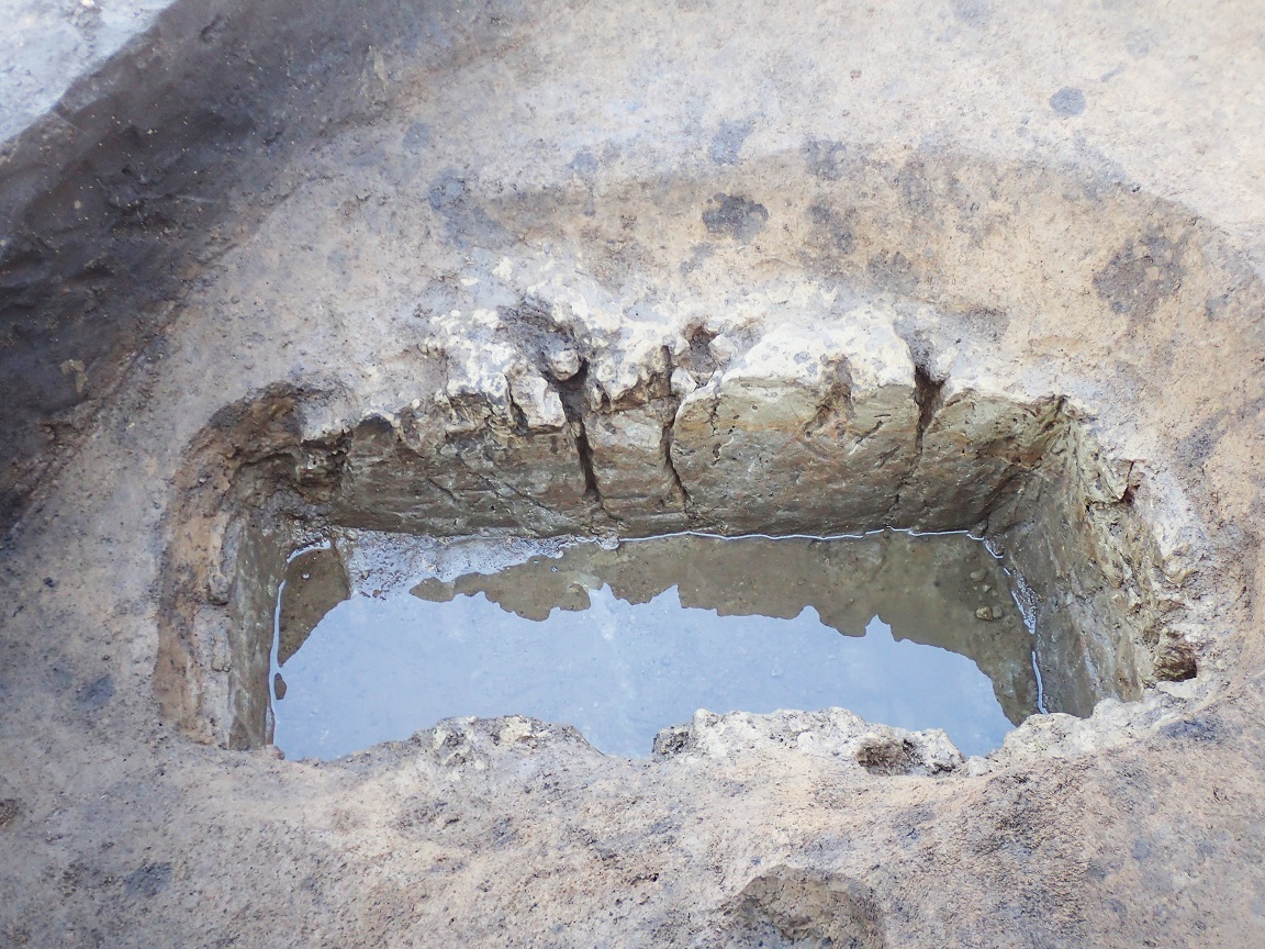水が溜まっている、長方形に掘られた深い穴の写真