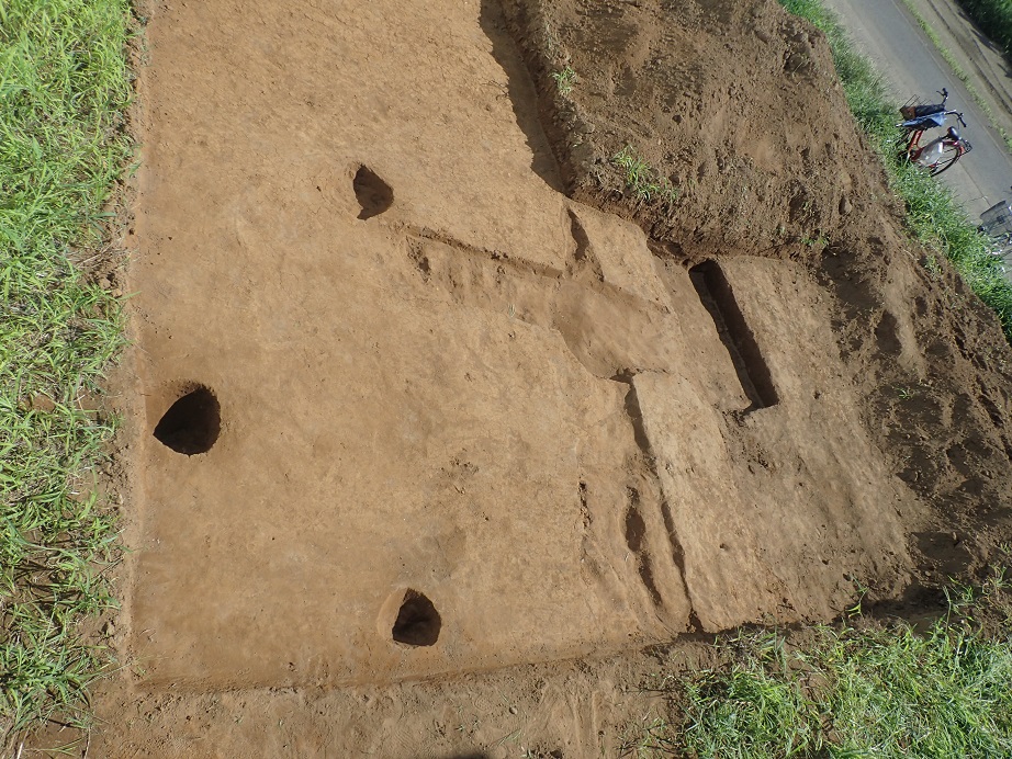 土が掘り起こされ、遺跡の跡が形どられて、所々に大小の穴や溝がある中妻遺跡の写真